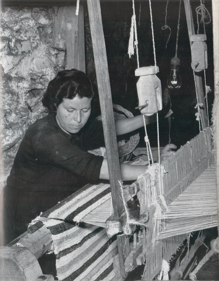 Mujer alpujarreña trabajando en un telar manual de madera en un interior de piedra